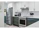 Bright kitchen featuring stainless steel appliances, white upper cabinets, and stylish lower cabinets at 13850 E Marina Dr # 606, Aurora, CO 80014