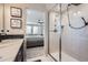 Main bathroom with double vanity, shower, and view into bedroom at 14461 Mosaic Ave, Parker, CO 80134