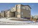 Two-story house with stone and siding exterior, snowy landscaping, and a wood fence at 14461 Mosaic Ave, Parker, CO 80134