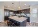 Modern kitchen with dark cabinets, quartz countertops, and an island at 14461 Mosaic Ave, Parker, CO 80134