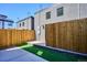 Backyard featuring privacy fence, concrete patio, and artificial grass at 1821 N Grove St, Denver, CO 80204