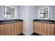 Bathroom with dual wood vanities, black marble floor, and modern lighted mirrors at 1821 N Grove St, Denver, CO 80204