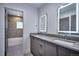 Modern bathroom featuring double sinks, lighted mirrors, and tiled accents with a view into the bath and shower at 1821 N Grove St, Denver, CO 80204