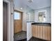 Bathroom featuring a glass shower with tile surround, black marble floors, and a wood vanity at 1821 N Grove St, Denver, CO 80204