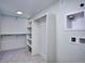 Walk-in closet with built-in shelving and washer/dryer hookups, with neutral colored walls and carpet at 1821 N Grove St, Denver, CO 80204