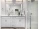 Modern bathroom with dual sinks, white cabinetry, and a glass-enclosed shower with built-in bench at 5371 E 63Rd Pl, Commerce City, CO 80022