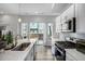Modern kitchen showcasing white cabinets, a stainless steel microwave, and plenty of light from the backyard window at 5371 E 63Rd Pl, Commerce City, CO 80022