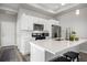 Modern kitchen with white cabinetry, stainless steel appliances, quartz countertops, and a functional island with seating at 5371 E 63Rd Pl, Commerce City, CO 80022