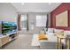 Bright living room with a large sectional sofa, television, and stylish décor, creating a comfortable space at 5371 E 63Rd Pl, Commerce City, CO 80022