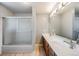 Bright bathroom with double vanity, glass shower and wood-look vinyl flooring at 6323 W Rowland Cir, Littleton, CO 80128