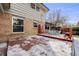 Snowy deck with outdoor dining set and brick siding on the house at 6323 W Rowland Cir, Littleton, CO 80128