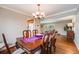 Traditional dining room with wood table, chandelier, and view into the living room at 6323 W Rowland Cir, Littleton, CO 80128