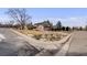 Exterior view of a two-story home, with mature landscaping, a lawn and a driveway at 6323 W Rowland Cir, Littleton, CO 80128