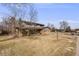 Traditional two-story home on large grassy lot with mature trees and blue sky at 6323 W Rowland Cir, Littleton, CO 80128