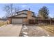 Charming two-story home boasts a brick chimney and attached two-car garage at 6323 W Rowland Cir, Littleton, CO 80128