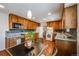 Kitchen with wooden cabinets, granite countertops, an eat-in breakfast table, and modern appliances at 6323 W Rowland Cir, Littleton, CO 80128