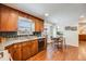 Bright kitchen with wooden cabinets, granite countertops, and views of the backyard at 6323 W Rowland Cir, Littleton, CO 80128