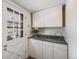 Bright mud room featuring white cabinets, granite countertops, and a glass panel door at 6323 W Rowland Cir, Littleton, CO 80128