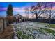 Large backyard with snowy grass, mature trees, outdoor seating, and a privacy fence, ideal for relaxation at 2455 Lowell Blvd, Denver, CO 80211