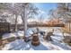 Large backyard with a pergola, seating area, fire pit, and snow-covered lawn at 2455 Lowell Blvd, Denver, CO 80211