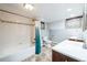 Bright bathroom featuring a tub with tiled walls, modern vanity, and decorative window accents at 2455 Lowell Blvd, Denver, CO 80211