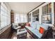 Cozy sunroom filled with natural light, brick accent wall, and comfortable seating arrangement at 2455 Lowell Blvd, Denver, CO 80211