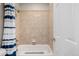 Tiled bathtub with blue striped shower curtain and white door at 1653 S Logan St, Denver, CO 80210