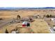 Aerial view of rural property with large barn, fenced paddocks, and surrounding fields and mountains at 200 Bothun Rd, Berthoud, CO 80513