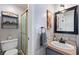 Neutral bathroom with a glass-door shower, single vanity, modern fixtures, and linen shelving at 200 Bothun Rd, Berthoud, CO 80513