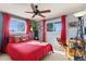 Inviting bedroom with red accents, two windows and a ceiling fan at 200 Bothun Rd, Berthoud, CO 80513