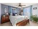 Well-lit bedroom with ceiling fan, light blue walls, and windows with views of mature trees at 200 Bothun Rd, Berthoud, CO 80513