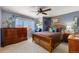 Comfortable bedroom with wood furnishings, ceiling fan, and bright natural light from the large window at 200 Bothun Rd, Berthoud, CO 80513