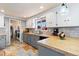 Bright kitchen featuring tile floors, countertops, white cabinets, a window, and a door to the laundry room at 200 Bothun Rd, Berthoud, CO 80513