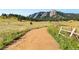Picturesque landscape featuring a dirt path leading towards the mountains and lush greenery at 200 Bothun Rd, Berthoud, CO 80513