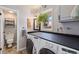 Laundry room with modern washer and dryer, built-in countertop, storage cabinets, and a bright window at 200 Bothun Rd, Berthoud, CO 80513