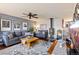 Inviting living room featuring dark wood floors, cozy seating, a ceiling fan and a wood burning stove at 200 Bothun Rd, Berthoud, CO 80513