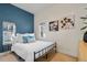 Stylish bedroom with a black metal bed frame, white bedding, and a blue accent wall at 103 Sunset St # A, Longmont, CO 80501