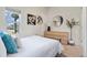 Bright bedroom featuring a large window, dresser, and white bedding with decorative pillows at 103 Sunset St # A, Longmont, CO 80501