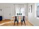 Bright dining area features a wood table, stylish black chairs, and natural light from a large window at 103 Sunset St # A, Longmont, CO 80501