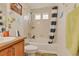 Cozy bathroom features tiled shower-tub with blue striped shower curtain and vanity with wood cabinets at 18090 E 47Th Dr, Denver, CO 80249