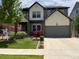 Well-kept two story home showing garage and landscaped front yard at 18090 E 47Th Dr, Denver, CO 80249