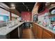 Basement bar features granite counters, wooden cabinets, and glass shelving for drink storage at 1586 S Goldbug Cir, Aurora, CO 80018
