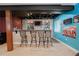 Entertaining basement bar area with stone accents, chairs, and storage at 1586 S Goldbug Cir, Aurora, CO 80018