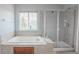 Bright bathroom features a soaking tub, separate shower, and large window for natural light at 1586 S Goldbug Cir, Aurora, CO 80018