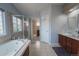 Bathroom features a soaking tub, separate shower, vanity with soft blue paint and neutral tile at 1586 S Goldbug Cir, Aurora, CO 80018