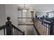 Bright hallway with decorative railing, connecting upper level living spaces with stairs to lower level at 1586 S Goldbug Cir, Aurora, CO 80018