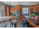 Stylish kitchen features wood cabinetry, black countertops and modern stainless steel double ovens and appliances at 1586 S Goldbug Cir, Aurora, CO 80018