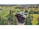 Aerial view of the cabin home surrounded by trees and green meadows at 3557 Palmer Ridge Dr, Parker, CO 80134