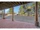 A covered patio with stone pillars extends into the backyard, with large trees in the distance at 3557 Palmer Ridge Dr, Parker, CO 80134