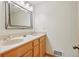 Bright bathroom with wood vanity, double sinks, and neutral wall paint at 3557 Palmer Ridge Dr, Parker, CO 80134